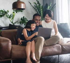 Family smiling around laptop